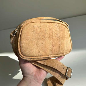 Hand holding the mini natural cork crossbody bag for size reference 