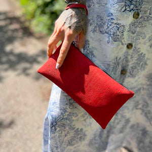 Model holding a red cork wrist wallet for women