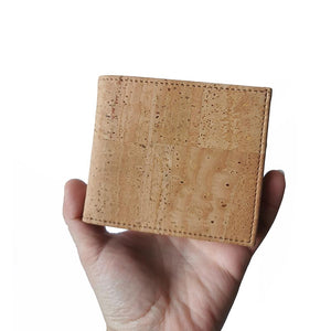 Model holding a natural cork bifold wallet for men 