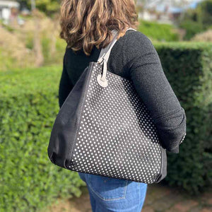 Model carrying the black and grey cork handbag on her shoulder