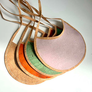 Round cork baby and toddler bibs in orange, green, pink and green cork