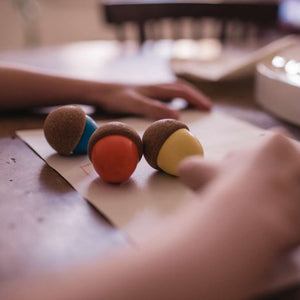 Toddler using our acorn-shaped cork crayons