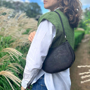 Model carrying the black cork half-moon bag on her shoulder