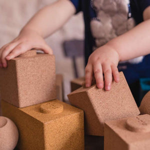 Toddler playing with the cork building blocks
