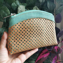 Load image into Gallery viewer, Hand holding the large cork purse with polka dot laser cuts in natural and turquoise-tinted cork