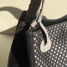 Load image into Gallery viewer, Detail of the removable handles and cut-outs of the black and grey cork handbag with cut-outs