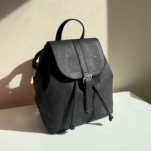 Load image into Gallery viewer, black cork drawstring backpack with folding top in natural light