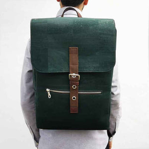 Model wearing a large green and brown vegan cork leather backpack with folding top
