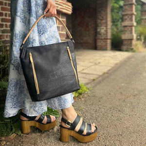 Model carrying a black and natural cork tote handbag
