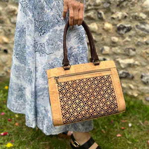 Model carrying a natural and brown cork handbag with tile cut outs