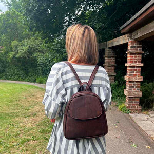 Model wearing a brown convertible cork backpack purse