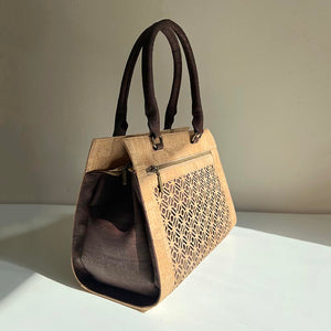 Natural and brown cork fabric handbag with Portuguese tile cut-outs in the sun, side view